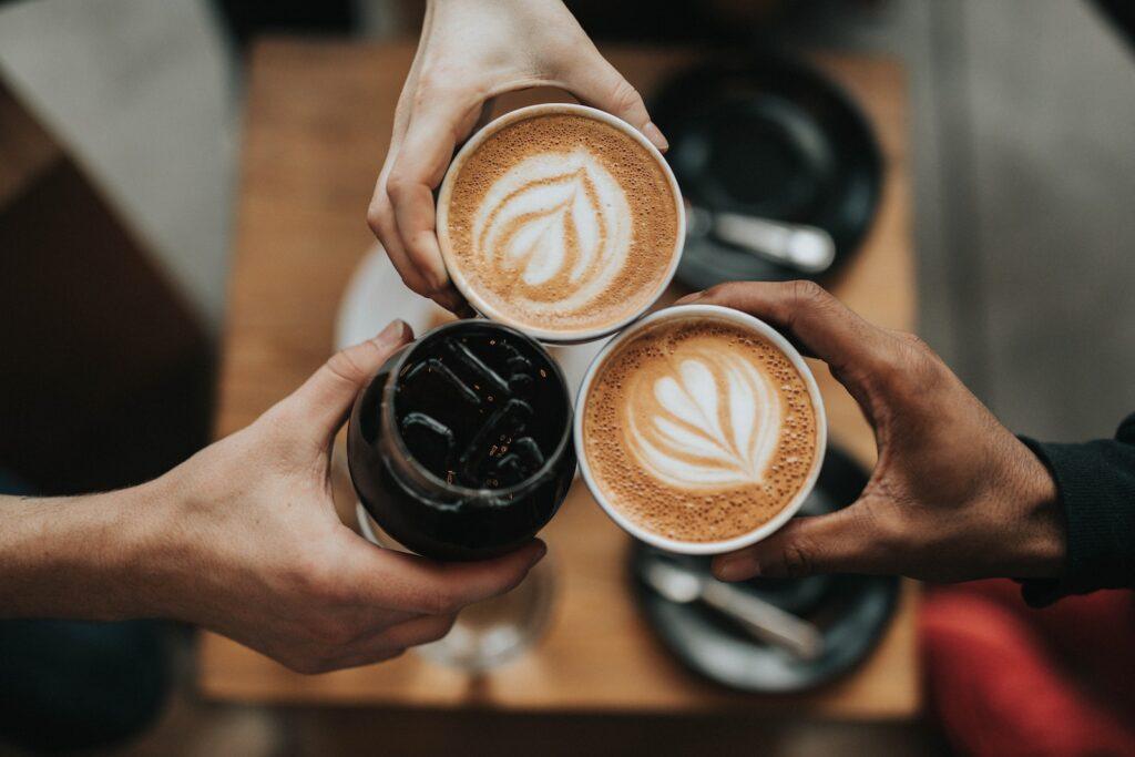 three person holding beverage cups, reusable coffee pods